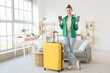 © Pixel-Shot - Beautiful young woman with passport, suitcase and modern mobile phone at home