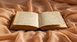 © Ayahe Stock - Antique book lies open, its aged pages displayed against soft, flowing, light-peach colored fabric