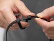 © Purnomo - Hands Securing a Black Zip Tie, Demonstrating Organization or Repair Skill