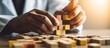 © gufron - Hands building a tower with wooden blocks, symbolizing strategy and development.