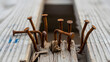 © Roy Arifin - Rusty nails protruding from weathered wood, conveying age and decay,A close-up view of corroded nails in a cracked wooden surface, highlighting texture and time