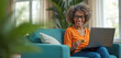 © Maryna - Elderly woman happily uses credit card for online shopping on laptop. Mature lady makes internet purchase on sofa, smiles at screen. Technology for seniors. Paying bills easily at home.