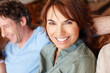 © peopleimages.com - Portrait, smile and woman on sofa in living room of home with husband for break or wellness. Bonding, chilling and relax with happy couple in apartment together for love, peace or rest on weekend