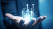 © Eshana - A hand holding digital arrows pointing upward, representing business growth and success concept