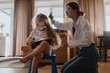© looking2thesky - A mother gently brushes her 4-year-old daughter's long beautiful hair. Authentic moment of family hair care, bonding and natural parenting love