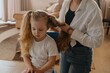 © looking2thesky - A mother gently brushes her 4-year-old daughter's long beautiful hair. Authentic moment of family hair care, bonding and natural parenting love