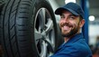 © Vadym - Young pro mechanic smiles brightly next to new car tires on rims. Auto service technician wears blue uniform and cap in a modern repair shop. He is ready for vehicle tire change, wheel maintenance.