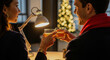 © Evgenii Starkov - Couple toasting drinks together in cozy home with Christmas tree lights, enjoying a romantic evening.