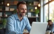© si - Businessman using laptop computer in office. Happy middle aged man, entrepreneur, small business owner working online. High quality