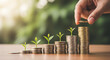 © jannatul - Hand placing coin on stack of coins with growing plants symbolizing financial growth and investment success