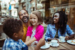 © Davor - Adult parents laughing with young son and daughter at street cafe