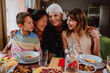 © oneinchpunch - Multi-generational family enjoying a meal together at home
