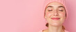 © NeuroCake - Smiling young woman wearing pink beanie and sweater. Happy female face with eyes closed on pink background. Winter fashion banner