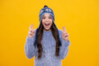 © Olena - Modern teenage girl 12, 13, 14 year old wearing sweater and knitted hat on isolated yellow background. Excited teenager girl.