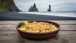 © Igor_Tichonow - baked fish and potato dish before black sand shore indicating icelandic tradition cold season comfort food and nordic coastal scenery