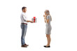 © Ljupco Smokovski - Full length profile shot of a man giving a present to a suprised woman