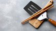 © BonzEarthsnapper - Cooking tools like spatula and chopsticks are essential for preparing teppanyaki dishes in vibrant Chinese market setting