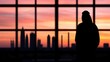 © Virtual Art Studio - A silhouetted figure gazes at a vibrant sunset skyline through large windows, framed by tall buildings and industrial structures.