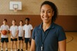 © Tor Gilje - A cheerful coach stands with her team in the gymnasium, ready for practice.