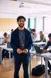 © Maskot - Portrait of smiling male high school professor standing in classroom