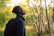 © Maskot - Contemplative male backpacker standing in forest