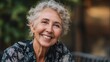 © วรรณภา มะโนศรี - Warm and Joyful Portrait of Senior Woman with Curly Hair Smiling Outdoors Surrounded by Nature in Soft Evening Light