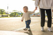 © leungchopan - Mother walking with her baby holding hands outdoors