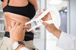 © lightpoet - Nutrition speacialist doctor woman measuring abdominal body fat on a woman. Belly chubby paunchy sport recreation health care lose belly fat concept.