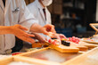 © ronnybas - Chefs prepare sushi for customers at a restaurant