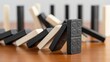 © ashan - Domino effect concept showing falling tiles on wooden surface illustrating business risk, chain reaction, and cause and effect