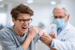 © Prazis Images - Young man screaming in pain from an injection