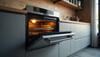 © miss irine - New oven with open door in modern kitchen. Silver electric appliance on wood tabletop at home. Contemporary equipment to prepare food. Interior of house with stove for cooking.