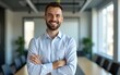 © wang - Portrait of cheerful businessman with arms folded standing in conference room. Happy young business man in shirt looking at camera. Portrait of a smiling businessman in modern office. High quality