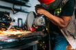© YanlethRivera - Metalworking professional using an angle grinder in the workshop. Man using a grinder in a workshop