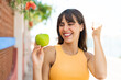 © luismolinero - Young woman with an apple at outdoors celebrating a victory