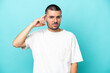 © luismolinero - Young caucasian man isolated on blue background having doubts