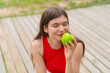 © luismolinero - Young pretty woman at outdoors holding an apple