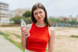 © luismolinero - Young pretty Ukrainian woman with a bottle of water at outdoors with sad expression