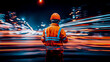 © sommersby - Nighttime urban scene with worker in hard hat and high-visibility jacket overlooking bustling street transformed by long-exposure light streaks
