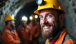 © Pete - Bearded man smiles in mine with crew. Miners wear safety helmets with headlamps. Miners stand in hard rock mine. Portrait of happy worker looking at camera in quarry.