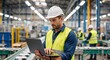 © Vasiliy - Industrial engineer using a laptop for quality control on a factory production line. Male worker in a hard hat supervising the manufacturing process