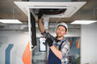 © Serhii - Hvac technician installing air conditioning unit in office building