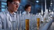 © Bussakon - Scientists working in a laboratory with rows of test tubes and flasks conducting experiments