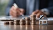 © juwairiya_nameera - Stacks of coins and house for financial investment