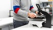 © SITI - Male worker pressing white t-shirt on heat press machine in printing workshop for custom apparel.