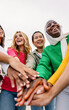 © Xavier Lorenzo - Close up of diverse women joining hands in unity outdoors. Young female friends symbolizing cooperation, support and trust. Friendship and empowerment concept.