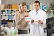 © JackF - Young woman in a European pharmacy scans a package of headache pills with a mobile barcode, she reads detailed instructions online. Payment for goods by QR code