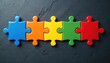 © Maryna - Five colorful puzzle pieces on dark grey backdrop. Blue orange yellow green and red jigsaw parts are connected. Symbolizes integration cooperation teamwork connection solutions and common goals.