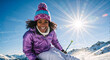© Milan - Happy young black woman skiing on a sunny winter day. Portrait of a smiling female skier enjoying a vacation in the snowy mountains with a sunburst in the background