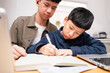 © myboys.me - Two Asian sibling study online learning, teenage brother teach younger boy with concentration and focus at home, write on notebook. Modern homeschool education, e-learning technology